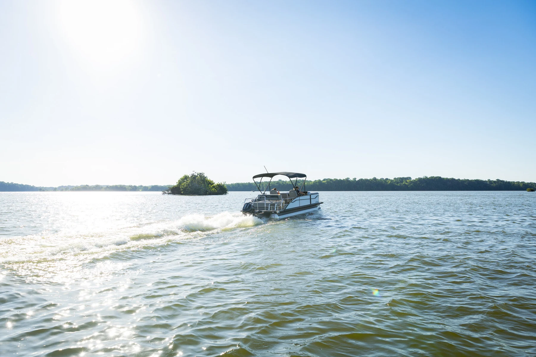A boat underway on open water in warm light.